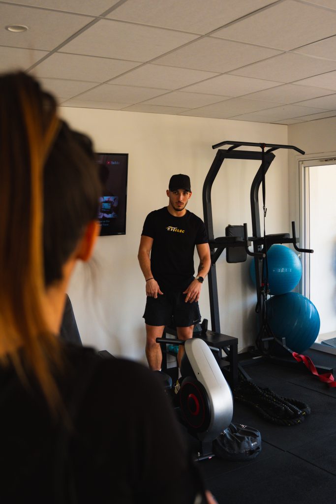 Coach debout dans le studio Fit'Elec