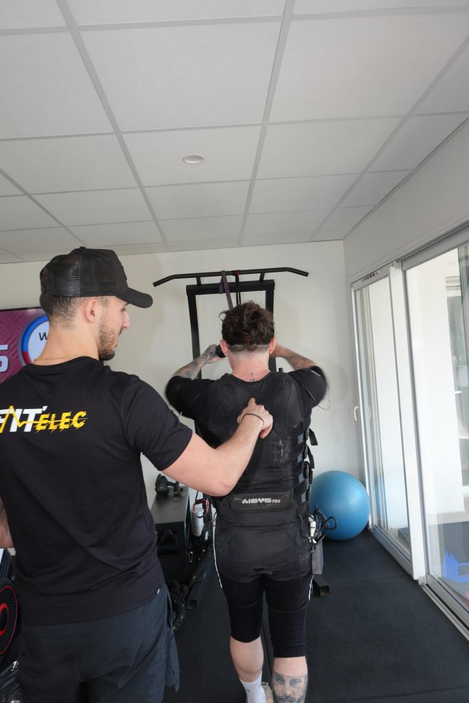 Coach ajustant le gilet EMS d'un client