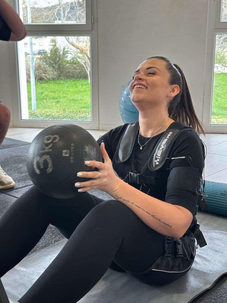 Médecine-ball et sourire pendant la séance d'électrostimulation