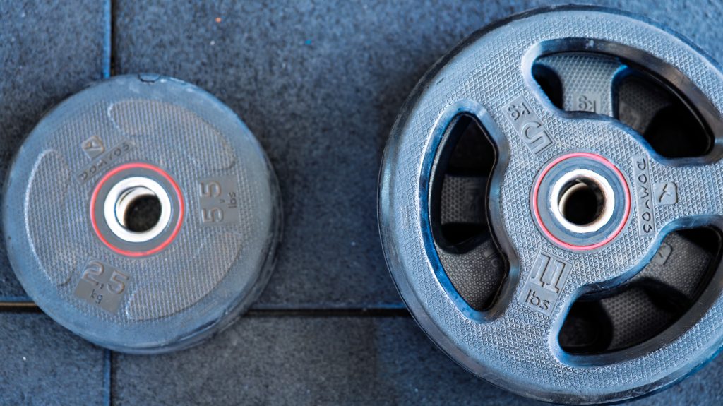 Disques de musculation au sol de la salle Fit'Elec