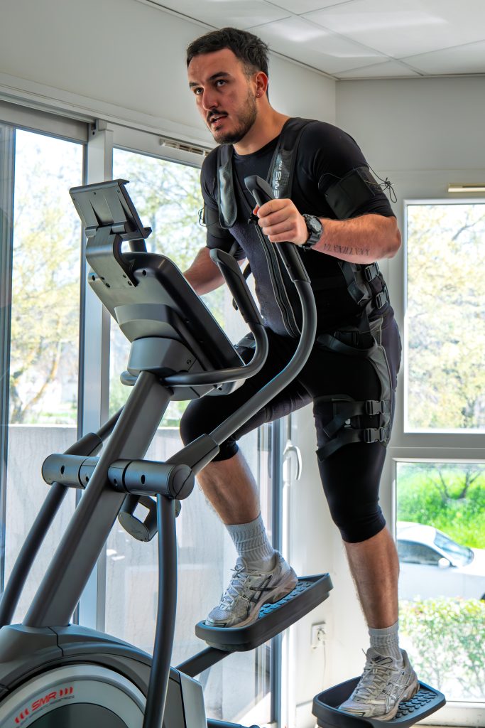 Client sur l'elliptique en combinaison d'électrostimulation