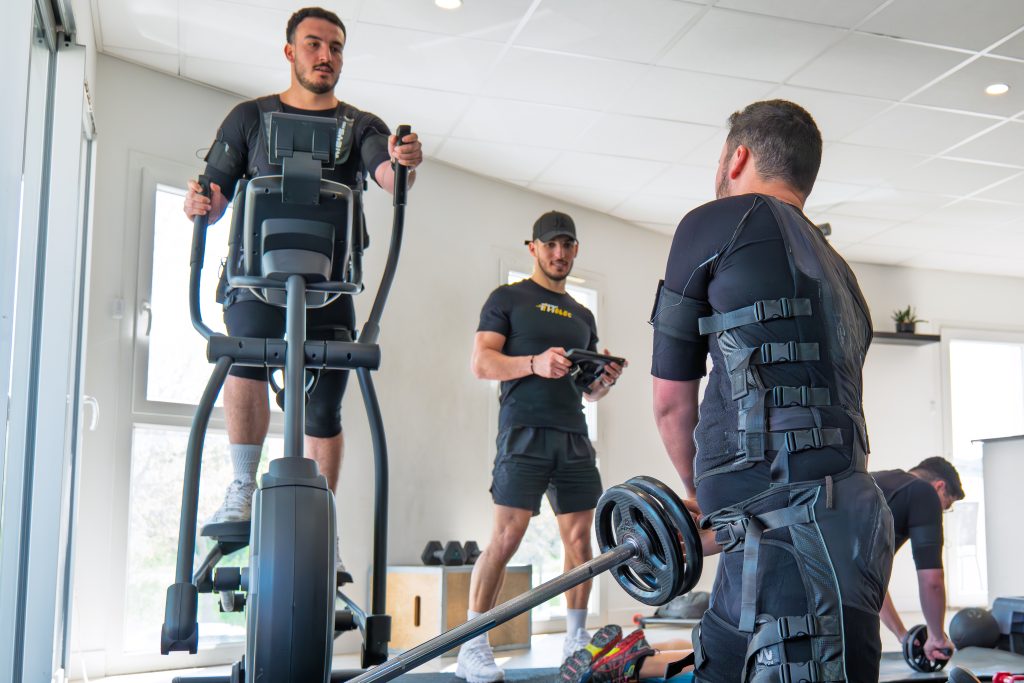 Coach suivant deux clients pendant une séance EMS