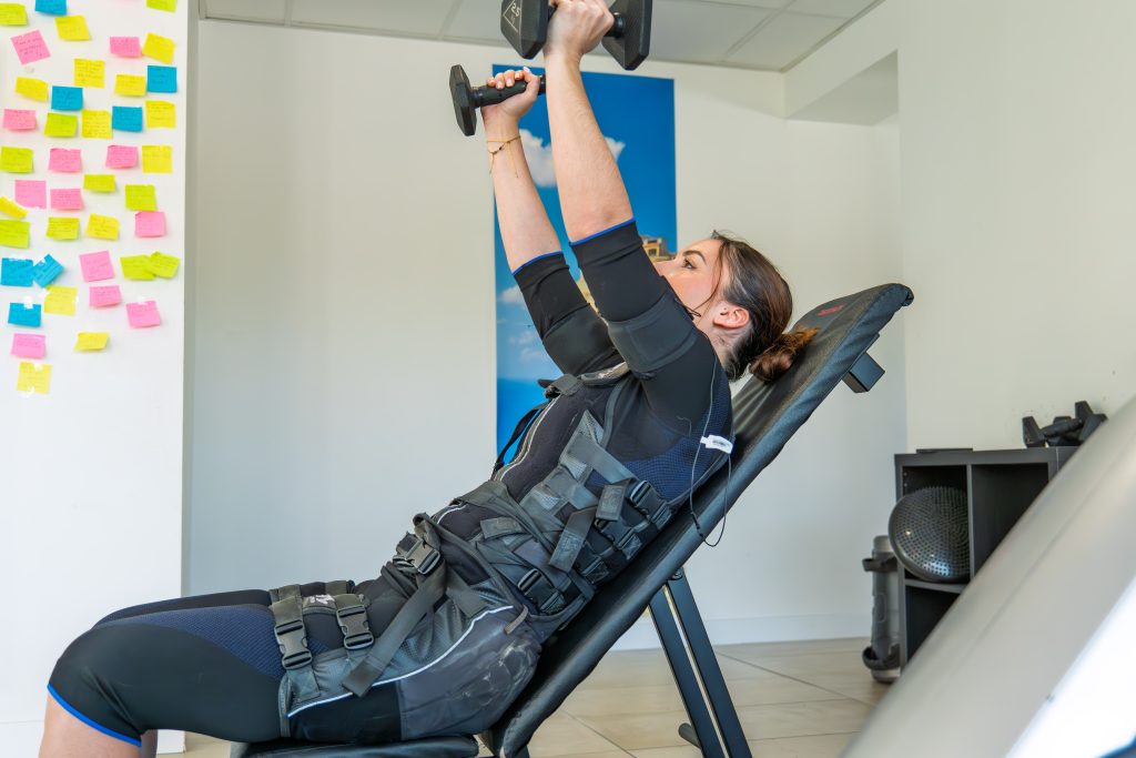 Cliente sur banc incliné avec haltère au studio