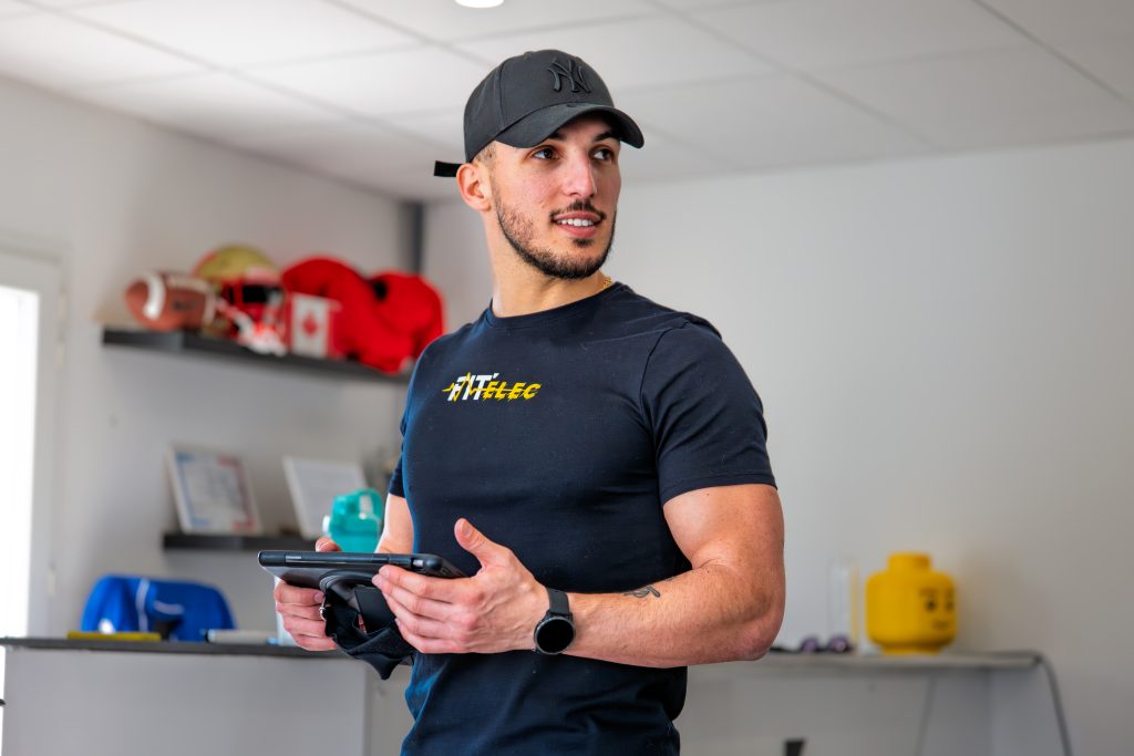 Coach Fit'Elec réglant l'intensité EMS sur sa tablette